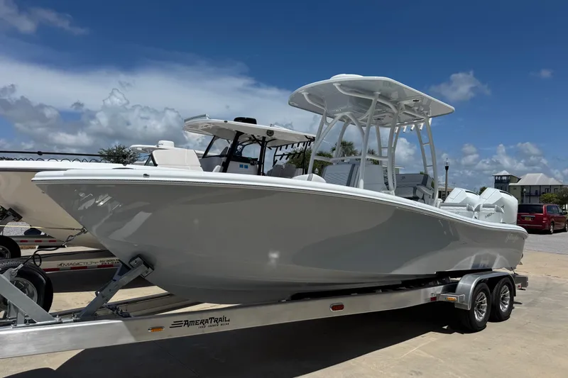 The Image of 2027 Yellowfin 26 Hybrid boat on trailer under clear blue sky. - 1