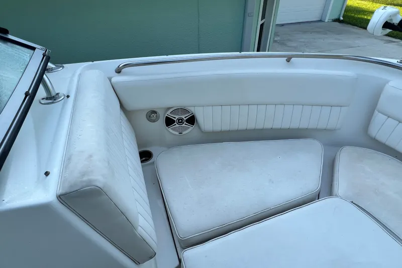 Slide: The Image of 2012 Robalo R247 Dual Console boat interior with white cushioned seating and speaker. - 32