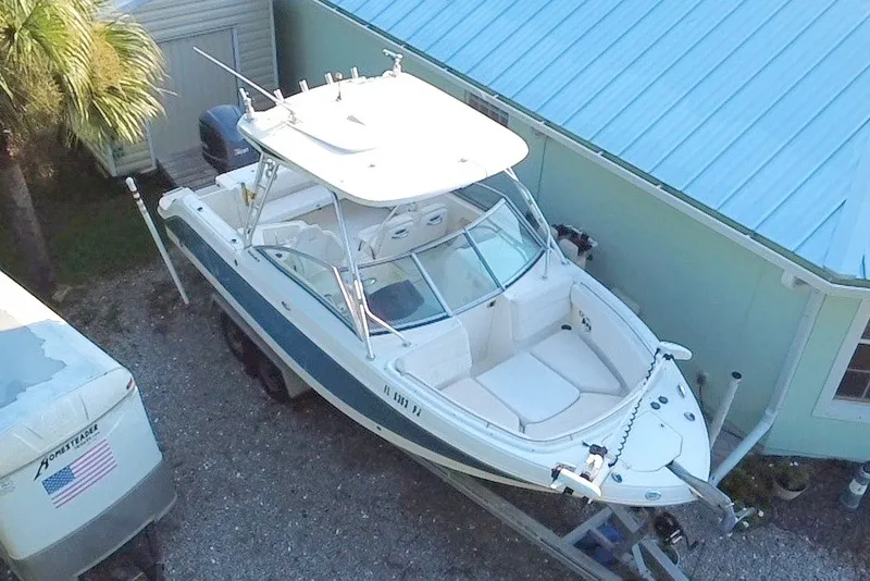 Slide: The Image of 2012 Robalo R247 Dual Console boat parked beside a blue house. - 6