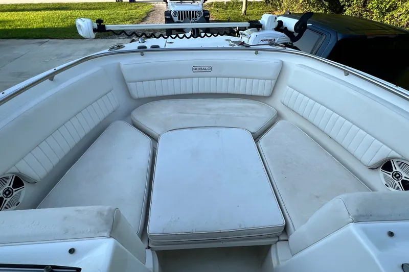 Slide: The Image of 2012 Robalo R247 Dual Console boat interior with white cushioned seating and speakers. - 30