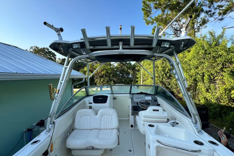 Slide: The Image of 2012 Robalo R247 Dual Console boat with seating and navigation equipment, surrounded by greenery. - 17