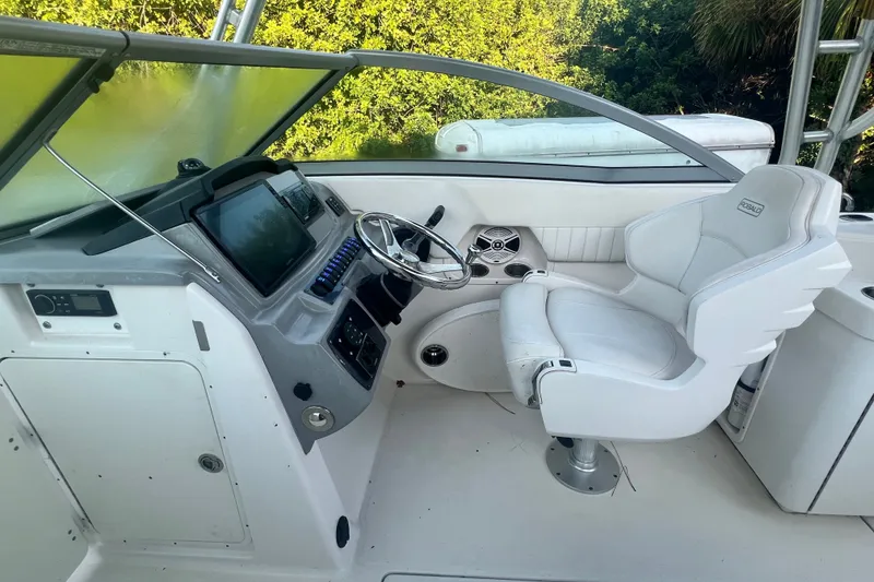 Slide: The Image of 2012 Robalo R247 Dual Console boat cockpit with steering wheel and captain's chair. - 21