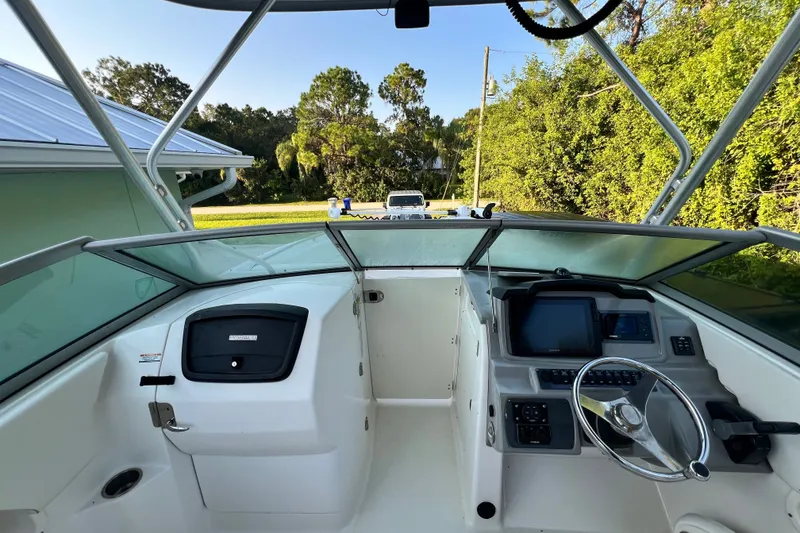 Slide: The Image of 2012 Robalo R247 Dual Console boat interior with steering wheel and dashboard controls. - 20