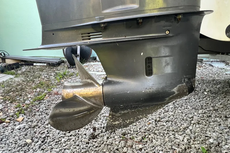 Slide: The Image of 2012 Robalo R247 Dual Console boat propeller on gravel surface. - 14