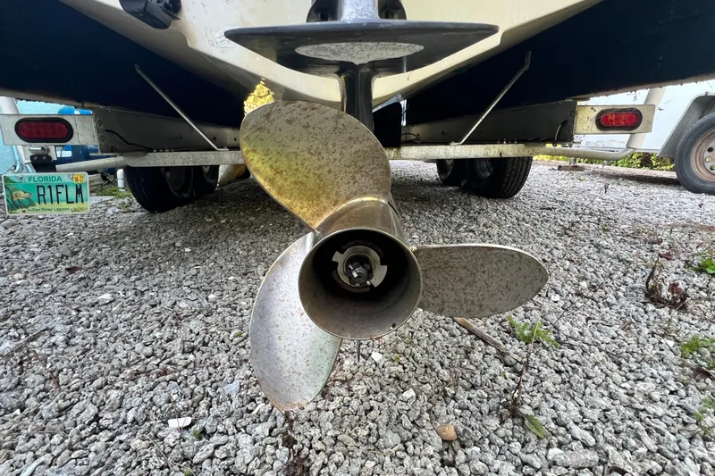Slide: The Image of Propeller of a 2012 Robalo R247 Dual Console boat on gravel surface. - 13