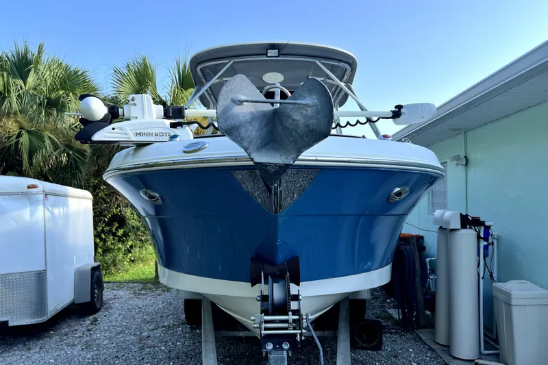 Slide: The Image of 2012 Robalo R247 Dual Console boat on trailer, blue hull, parked near palm trees. - 3