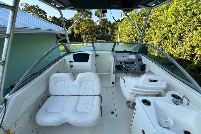 Slide: The Image of 2012 Robalo R247 Dual Console boat interior with white seating and Garmin navigation system. - 18