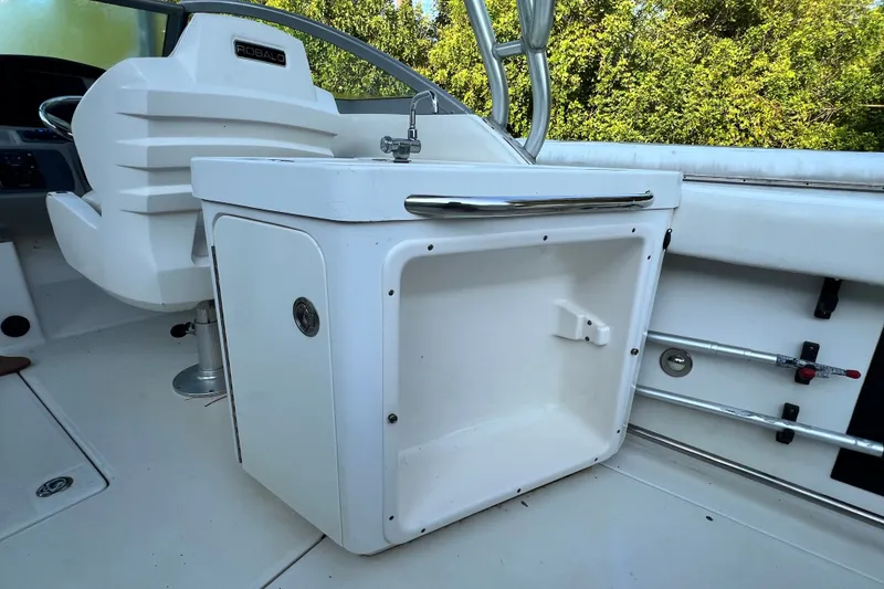 Slide: The Image of 2012 Robalo R247 Dual Console boat interior with sink and storage compartment. - 23