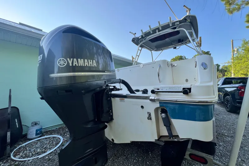 Slide: The Image of 2012 Robalo R247 Dual Console boat with Yamaha outboard motor, parked on gravel. - 11