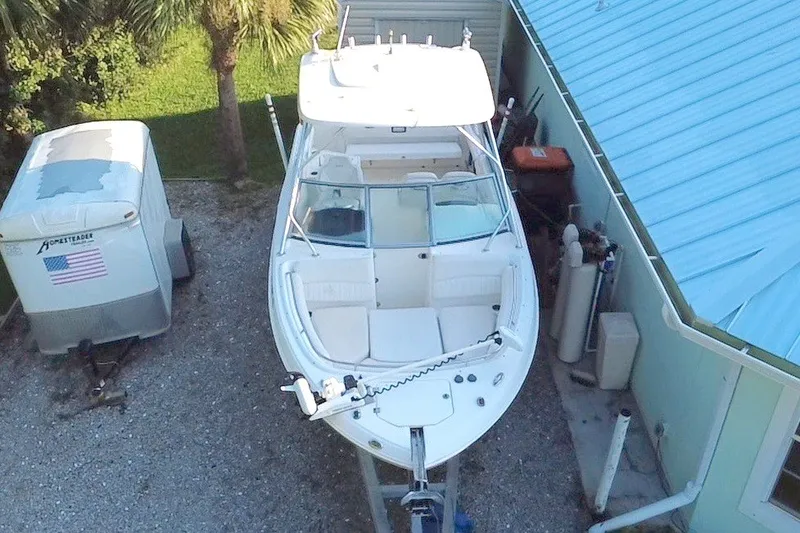 Slide: The Image of 2012 Robalo R247 Dual Console boat parked beside a blue-roofed building. - 8