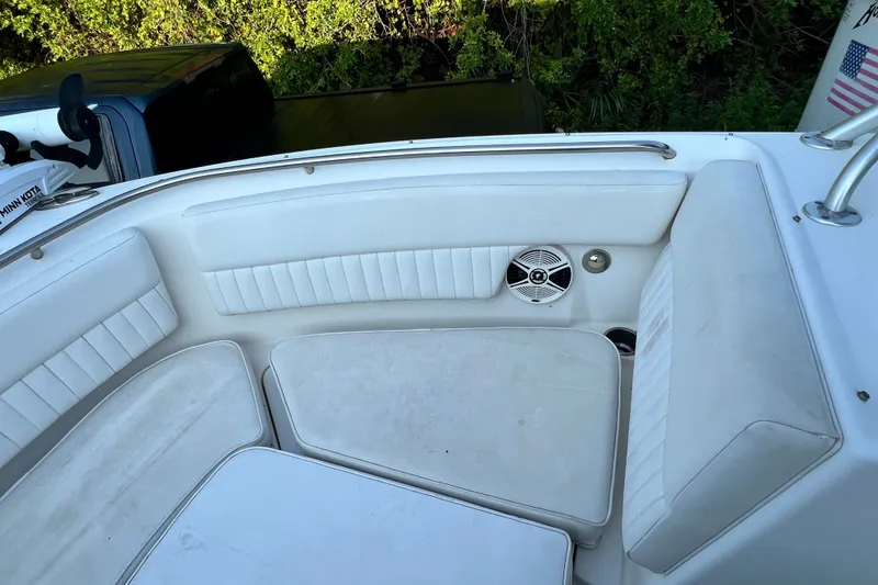 Slide: The Image of 2012 Robalo R247 Dual Console boat interior with white cushioned seating and speaker. - 31