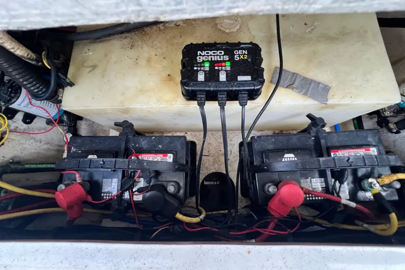 Slide: The Image of Battery compartment with two batteries and a NOCO Genius charger in a Robalo R247 Dual Console boat. - 40