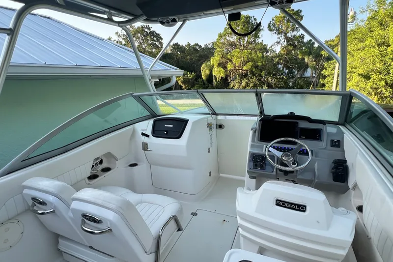 Slide: The Image of 2012 Robalo R247 Dual Console boat interior with steering wheel and seating. - 19