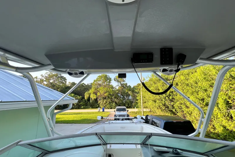 Slide: The Image of 2012 Robalo R247 Dual Console boat interior with electronics and speakers, parked outdoors. - 29