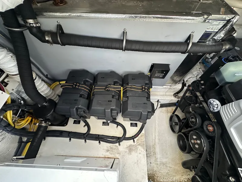 Slide: The Image of The engine room of a 2017 Cruisers Yachts 350 Express shows batteries and engine components. - 28