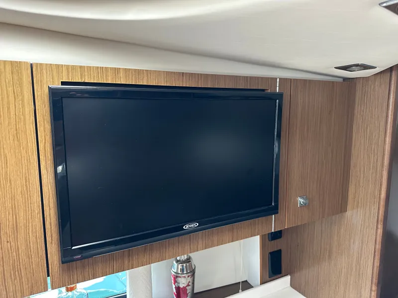 Slide: The Image of A modern TV is mounted on a wooden wall inside a yacht. - 18