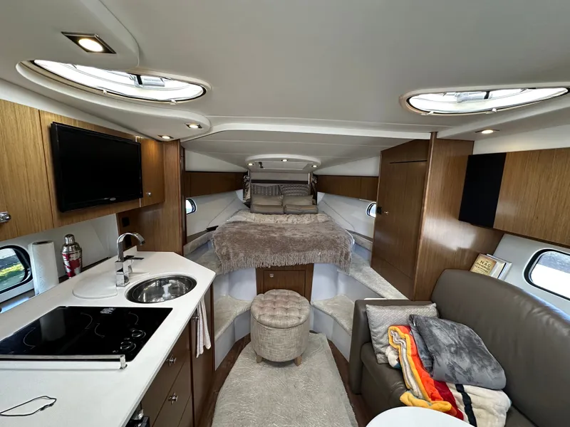 Slide: The Image of Interior of the 2017 Cruisers Yachts 350 Express with cozy bed, kitchenette, and sofa. - 24