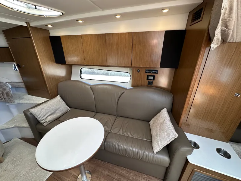 Slide: The Image of Interior of the 2017 Cruisers Yachts 350 Express with leather sofa and wooden cabinetry. - 20