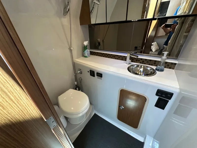 Slide: The Image of The image shows the bathroom of a 2017 Cruisers Yachts 350 Express with a toilet and sink. - 21
