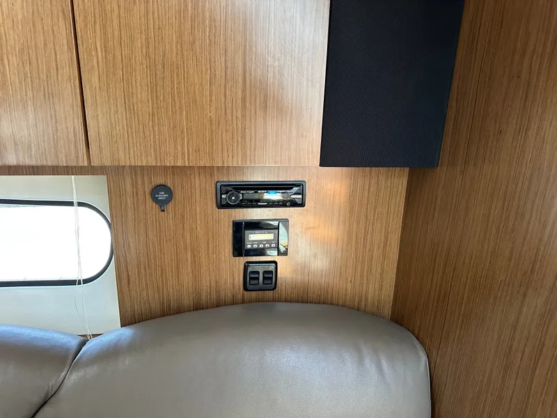 Slide: The Image of Interior of the 2017 Cruisers Yachts 350 Express with wood paneling and entertainment system. - 17