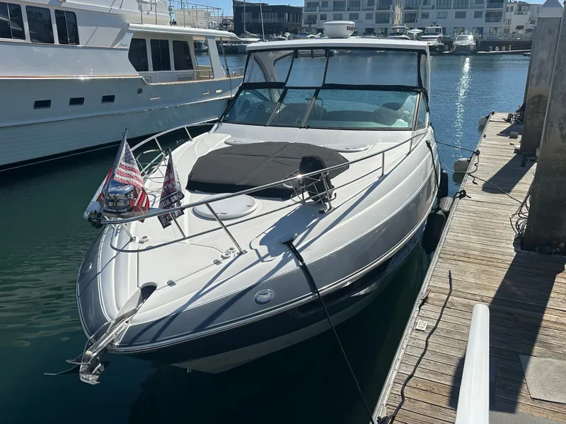 Slide: The Image of 2017 Cruisers Yachts 350 Express docked, featuring American flags, in a marina setting. - 31