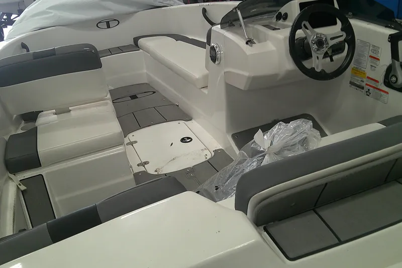 Slide: The Image of 2026 Tahoe T16 boat interior with gray and white seating and steering console. - 6