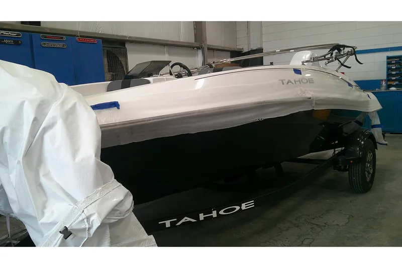 The Image of 2026 Tahoe T16 boat in a garage, partially covered, on a trailer. - 0