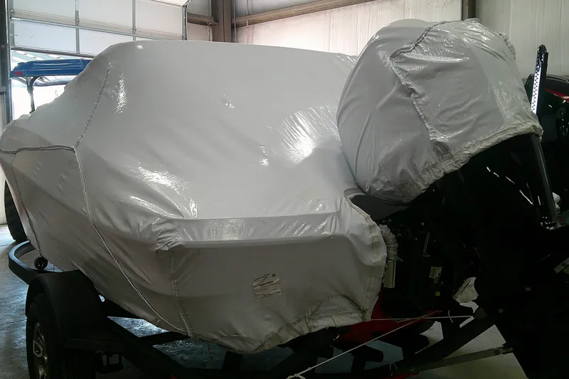Slide: The Image of 2026 Tahoe T18 boat covered in protective wrap on a trailer in a garage. - 8