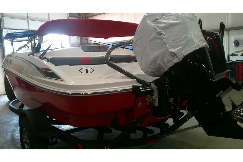 Slide: The Image of 2026 Tahoe T18 boat in a garage, featuring a red and white design with an outboard motor. - 4
