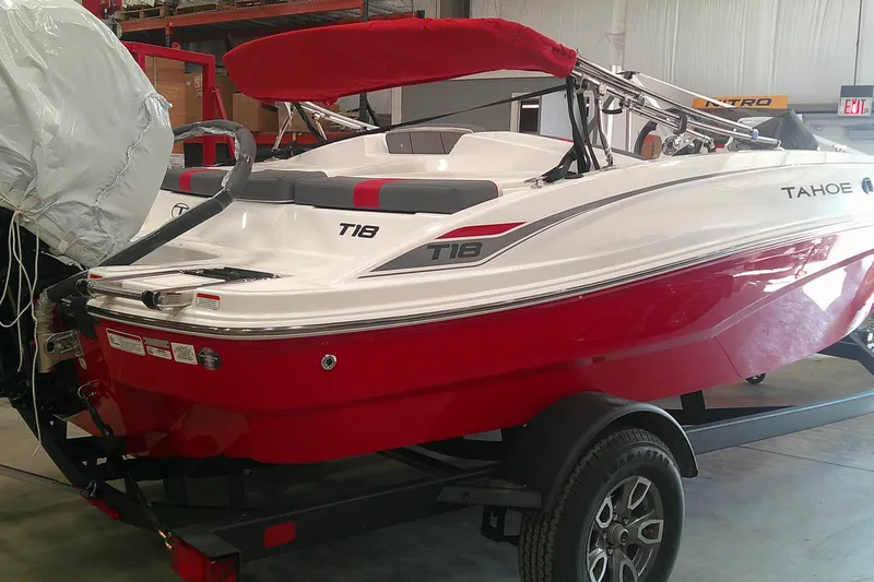 The Image of 2026 Tahoe T18 boat with red and white design in a showroom setting. - 0