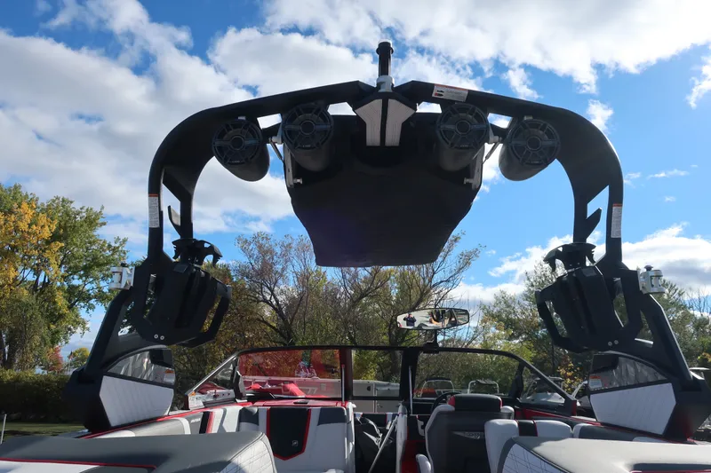 Slide: The Image of 2019 Nautique Super Air Nautique G23 boat with tower speakers and seating, under blue sky. - 10
