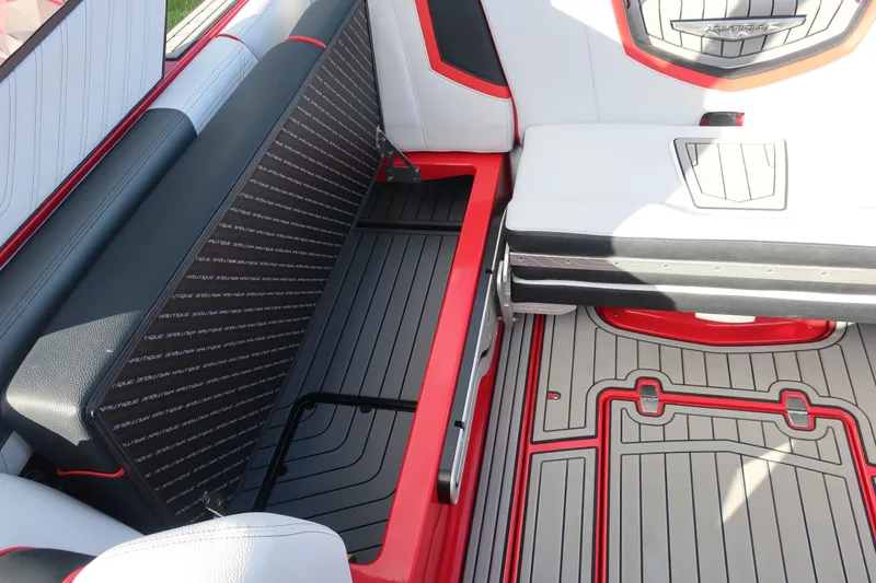 Slide: The Image of 2019 Nautique Super Air Nautique G23 interior seating with storage, featuring red and black accents. - 21