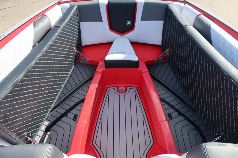Slide: The Image of 2019 Nautique Super Air Nautique G23 boat interior with red and gray seating. - 2