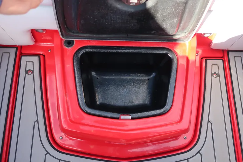 Slide: The Image of Open storage compartment on 2019 Nautique Super Air Nautique G23 boat, featuring red and gray design. - 29