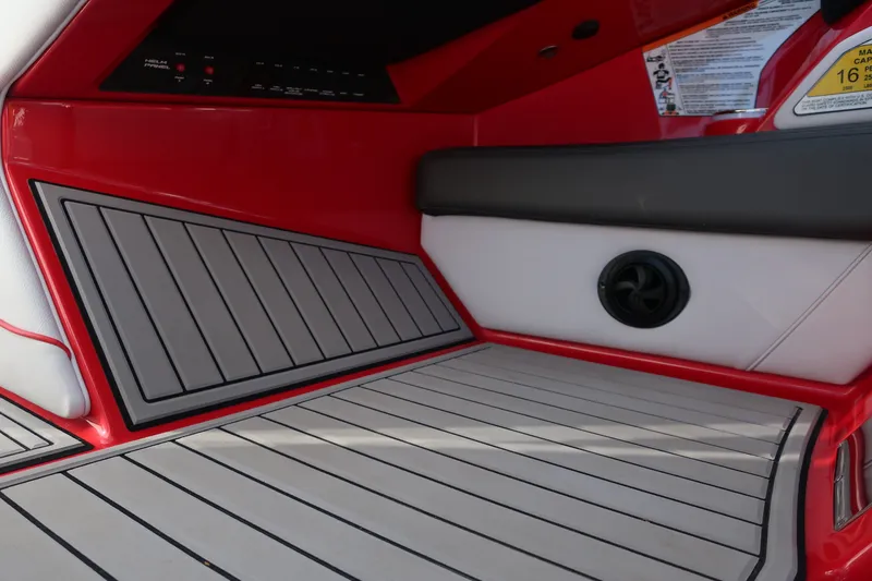 Slide: The Image of 2019 Nautique Super Air Nautique G23 interior with red and white seating and gray flooring. - 25