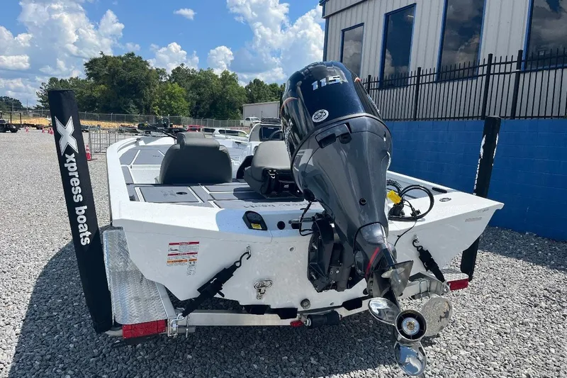Slide: The Image of 2027 Xpress H18 Bass boat with powerful outboard motor, parked on gravel lot. - 15