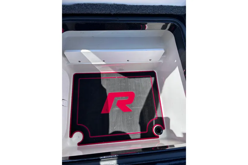 Slide: The Image of 2024 Ranger Z520R boat compartment with red logo and black mat. - 30