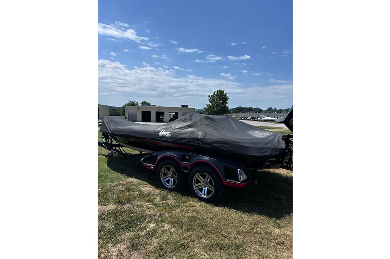 Slide: The Image of 2024 Ranger Z520R boat covered, parked on grass under a clear blue sky. - 40