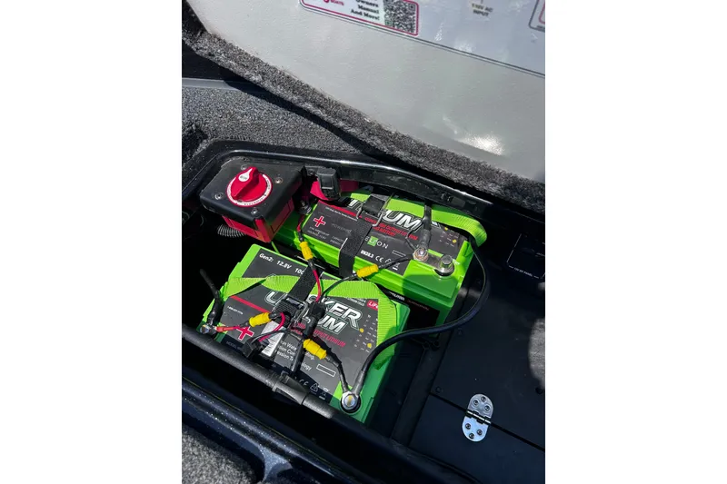 Slide: The Image of 2024 Ranger Z520R boat battery compartment with lithium batteries and power switch. - 33