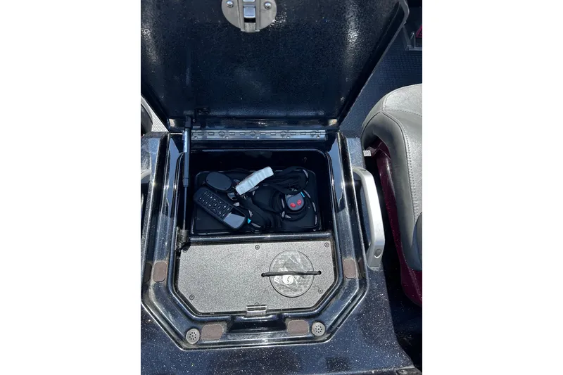 Slide: The Image of Open storage compartment in 2024 Ranger Z520R boat, containing electronic accessories. - 24