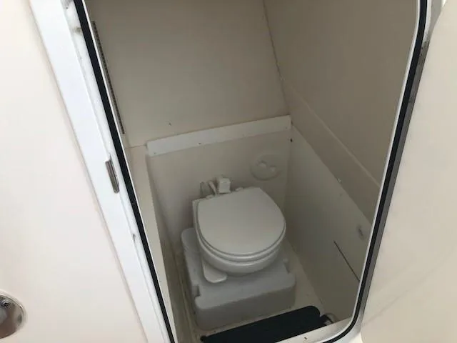 Slide: The Image of The image shows a compact boat toilet in a small, white space. - 11
