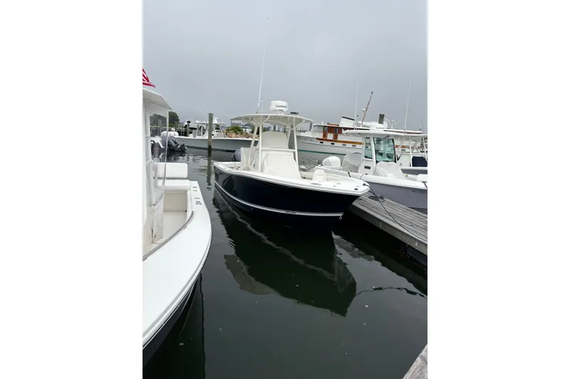 Slide: The Image of 2014 Regulator 23 Forward Seating boat docked at a marina on a cloudy day. - 9