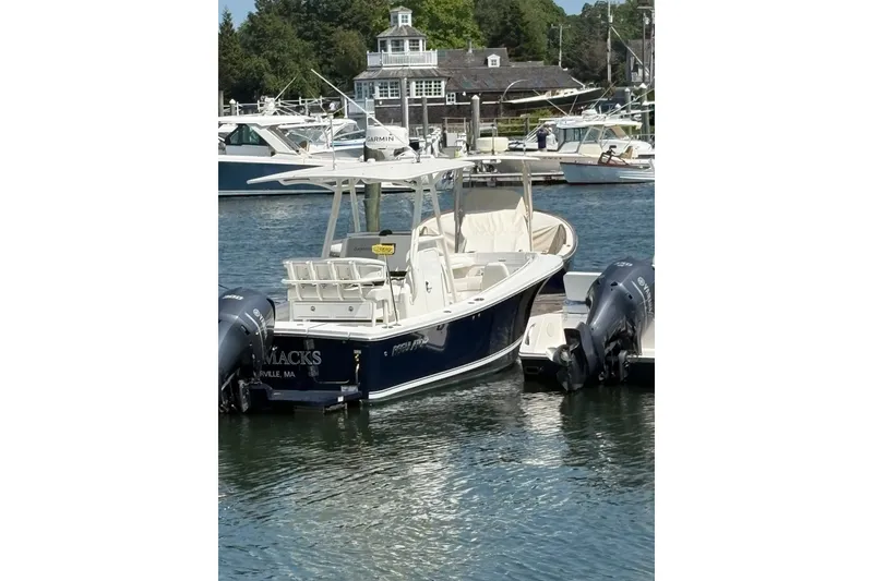 Slide: The Image of 2014 Regulator 23 Forward Seating boat docked in a marina with twin outboard engines. - 4