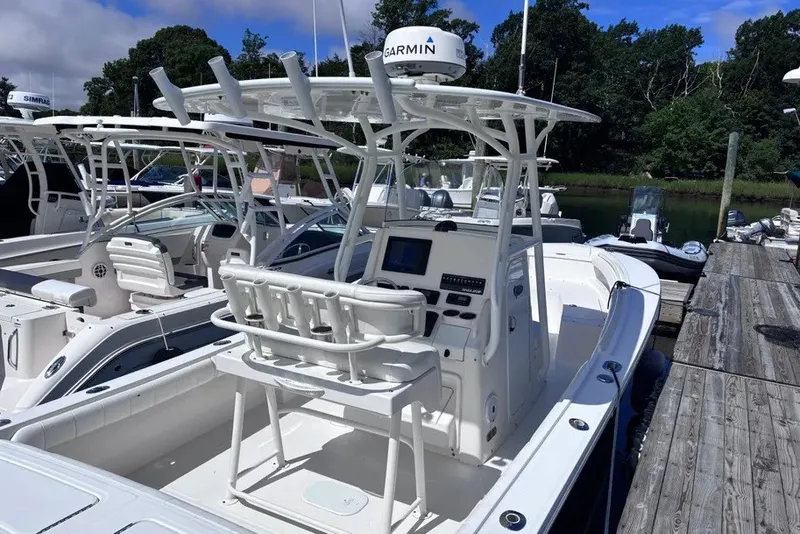 Slide: The Image of 2014 Regulator 23 Forward Seating boat docked, featuring Garmin equipment and spacious seating. - 3