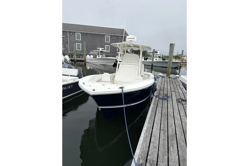 Slide: The Image of 2014 Regulator 23 Forward Seating boat docked at marina, featuring sleek design and Garmin equipment. - 2