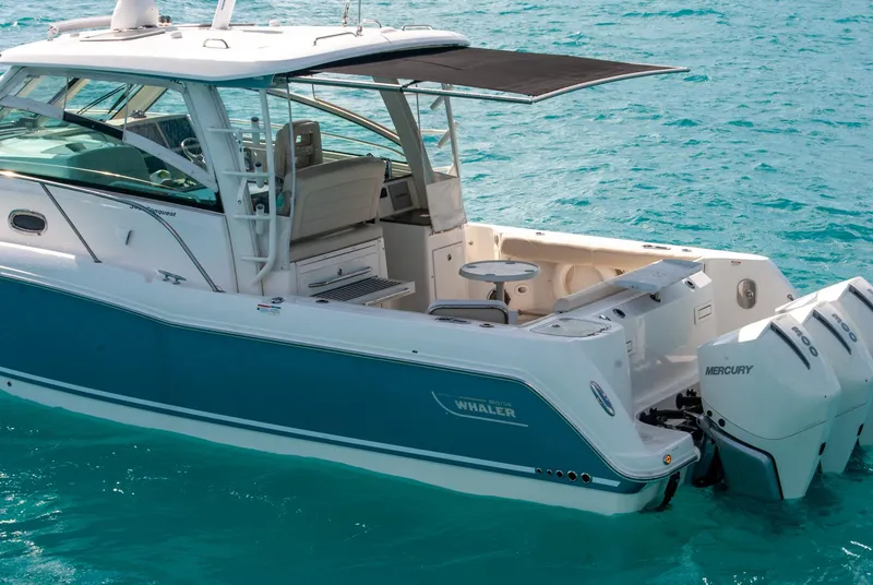 Slide: The Image of 2021 Boston Whaler 345 Conquest boat on turquoise water, featuring twin Mercury engines. - 13
