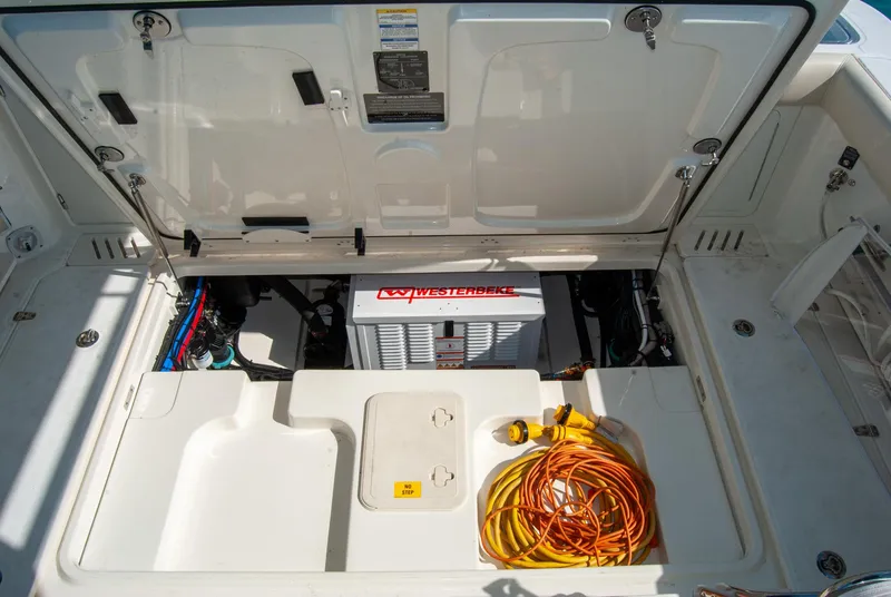 Slide: The Image of 2021 Boston Whaler 345 Conquest engine compartment with Westebeke generator and coiled power cords. - 46