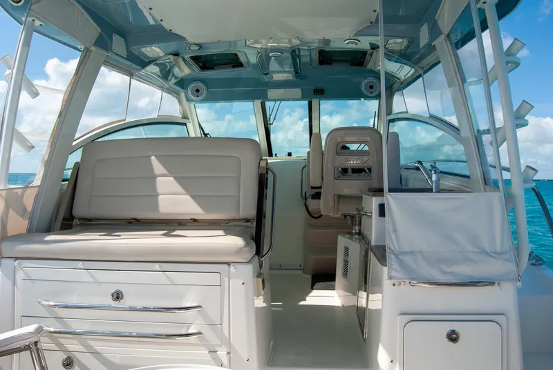 Slide: The Image of 2021 Boston Whaler 345 Conquest interior with seating and helm, under clear blue skies. - 11