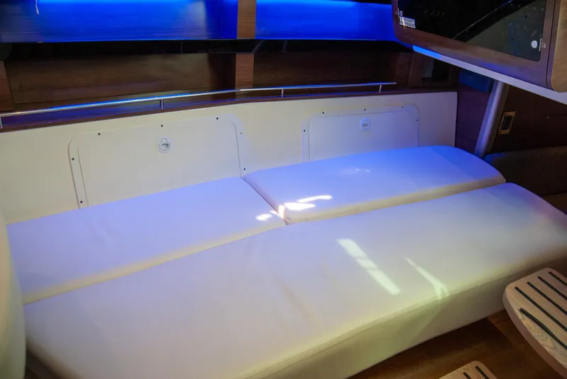 Slide: The Image of 2021 Boston Whaler 345 Conquest interior with white seating and ambient blue lighting. - 33