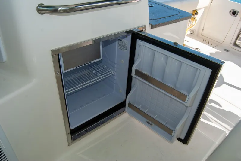 Slide: The Image of Open refrigerator on 2021 Boston Whaler 345 Conquest boat, showcasing interior storage space. - 20